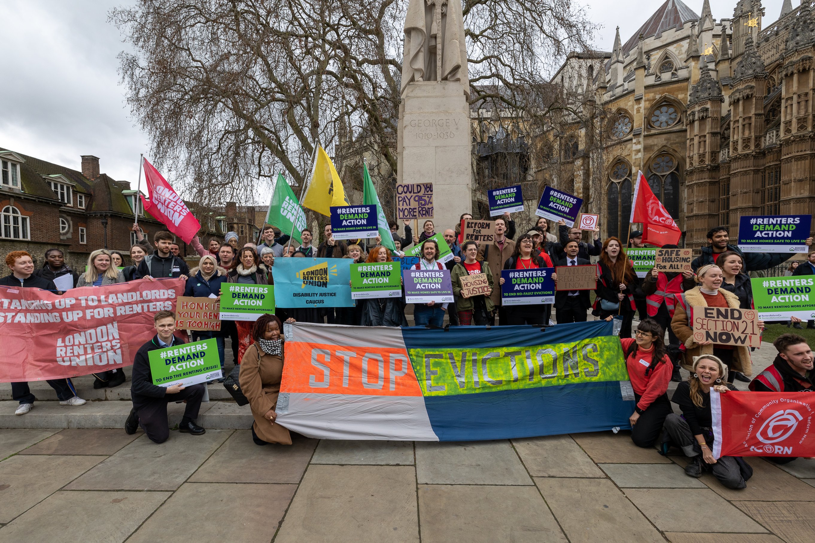 An image of a large group of people holding banners reading 'stop evictions' and similar
